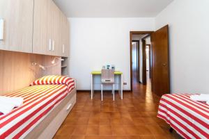 a room with two beds and a desk in it at Casa Magnodeno in Lecco