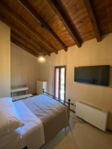 a bedroom with a large bed and a flat screen tv at Agriturismo Pizzavacca in Villanova sullʼArda