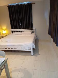 un letto bianco in una stanza con tenda nera di AT home hotel a Hua Hin