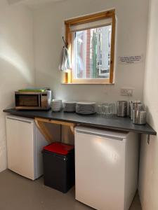 a kitchen with a counter with a microwave and a window at Portland Outdoor Centre Hostel in Portland