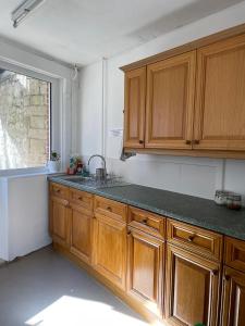 a kitchen with wooden cabinets and a sink and a window at Portland Outdoor Centre Hostel in Portland