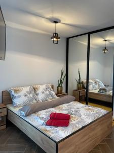 a bedroom with a bed with a red pillow on it at Lux Apartment in Rzeszów