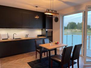 a kitchen with a table and chairs and a kitchen with a window at Lux Apartment in Rzeszów