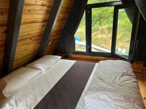 a bed in a room with two windows at Kalivi suit bungalov 1 in Ardeşen