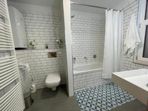 a bathroom with a toilet and a tub and a sink at Apartament in Brussels