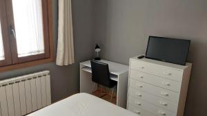 1 dormitorio con escritorio y vestidor con TV en Apartamento en Villanua La Espata, en Villanúa