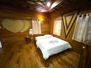 a bedroom with a bed with a heart painted on the wall at MAGMAI HOMESTAY & TOWER in Tak