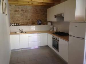 a kitchen with white cabinets and a sink and a stove at 8 Gite Complex, 53 People maximum , Marriage, Birthdays, family get togethers in Doeuil-sur-le-Mignon