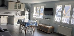 a kitchen with a table and chairs and a kitchen with windows at Port de La Houle - Beau 3 pièces classé 3 étoiles avec garage privé in Cancale
