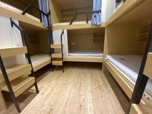 a room with two bunk beds and a wooden floor at Chengdong Yishu Inn Youth Hostel in Hangzhou
