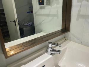 uma casa de banho com um lavatório e um espelho por cima. em Chengdong Yishu Inn Youth Hostel em Hangzhou