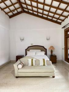 a bedroom with a large bed with a couch at Rumah di Patra Kuningan, Jaksel in Jakarta