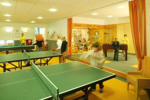 a group of people in a room with ping pong tables at Feriendorf Reichenbach - Dachspfad 6 in Nesselwang