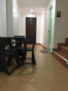 a hallway with two black chairs and a door at Marion's Inn Bldg 2 Bantayan powered by Cocotel in Bantayan Island