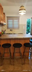 a kitchen with four bar stools at a counter at Leodi Place in Vathí
