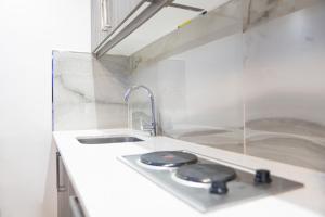 a kitchen counter with a sink and a faucet at G&D Guesthouse in Cape Town