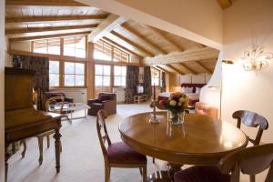 a living room with a table and a piano at Hotel Angela in Lech am Arlberg