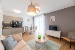 a living room with a couch and a table at OVELIA Lyon - Les Jardins d'Hortense in Lyon