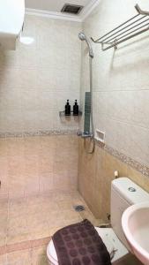 een badkamer met een douche, een toilet en een wastafel bij Cottonwood Midcentury Apartment at Majesty 811 in Bandung
