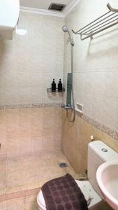a bathroom with a shower and a toilet and a sink at Cottonwood Midcentury Apartment at Majesty 811 in Bandung