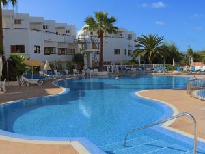 a large swimming pool in a resort with palm trees at Playa Ajabo Beachfront Apartment in Callao Salvaje