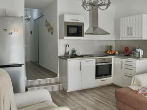 cocina con armarios blancos y nevera en Playa Ajabo Beachfront Apartment en Callao Salvaje