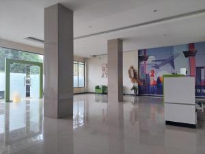 a lobby with columns and paintings on the walls at Grand Tawiri Hotel 