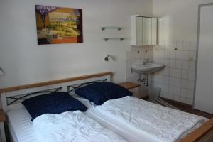 a bed with two pillows and a sink in a room at Feriendorf Reichenbach - Dachspfad 7 in Nesselwang