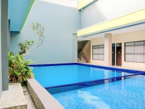 a swimming pool in a building with blue water at Grand Tawiri Hotel 