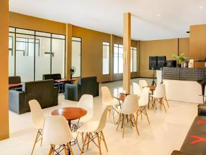 a dining room with white chairs and tables at Grand Tawiri Hotel 