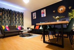 Enfield North London 3BR Apartment في لندن: غرفة معيشة مع طاولة وأريكة