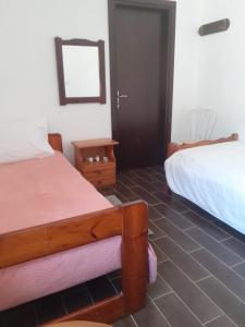 um quarto de hotel com duas camas e uma porta em Lefkogia Cottage em Lefkogeia