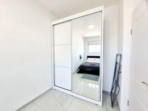 um espelho grande num quarto branco com uma cama em "Robert Sold Zugit" from Shneider apartments em Qiryat Shemuʼel