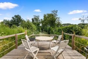 a wooden deck with a table and chairs at Little Moat - Moat Farm Barns a small modern studio in the garden on our family farm in Evesham