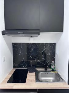 a kitchen counter with a sink and a microwave at Le Madeleine - Cosy & Rénové - Face Tram in Orléans