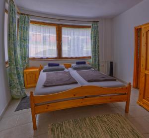 1 dormitorio con cama de madera frente a una ventana en Chill House en Orfű