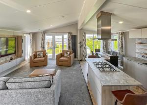 a large living room with a couch and a stove at Sandgreen Caravan Park in Girthon