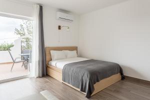 um quarto branco com uma cama e uma varanda em JOIVY Superb studio with patio in Faro em Faro