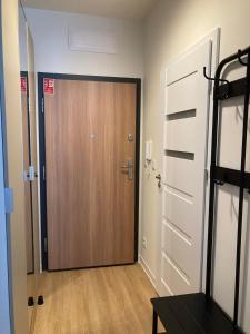 drewniane drzwi w pokoju z drewnianą podłogą w obiekcie Apartament studio Perła 2 w mieście Lublin