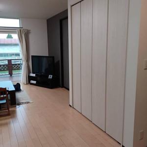 sala de estar con TV y puerta corredera en アンドステイ上士幌 en Kami-shihoro