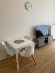jadalnia z białym stołem i krzesłami oraz zegarem w obiekcie Apartament studio Perła 2 w mieście Lublin