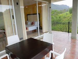 un balcone con tavolo e sedie e un letto di Mountain Villa a Suriyakanda