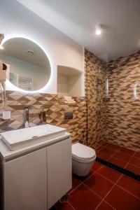 a bathroom with a white sink and a toilet at Urban Apartments 23 in Tbilisi City
