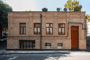 a brick building with a red door and windows at Urban Apartments 23 in Tbilisi City