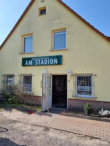 un bâtiment avec un panneau indiquant am station dans l'établissement Pension Am Stadion, à Kölleda