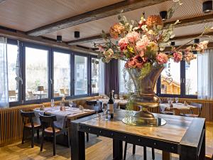ein Restaurant mit einem Tisch mit einer Blumenvase darauf in der Unterkunft Restaurant & Hotel Heidelberg in Aadorf