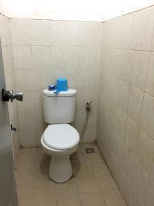 OYO Life 93009 Griya Nautika Sedati في سيدوارجو: حمام مع مرحاض عليه صندوق ازرق