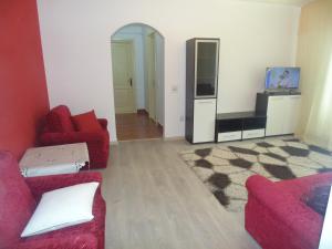 スチャヴァにあるLary apartamentのリビングルーム(赤いソファ2台、テレビ付)