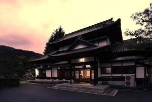 ein chinesisches Gebäude mit Sonnenuntergang im Hintergrund in der Unterkunft 会津東山温泉　鶴我東山総本山 in Aizu-Wakamatsu