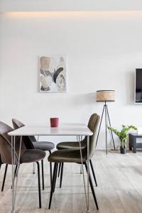 a dining room with a white table and chairs at Venture Vacations - 65 TV Netflix Free Parking King Bed Brand New in Reykjavík
